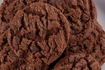 Tasty chocolate chip cookies on white plate on wooden background. Selective focus.