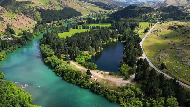 Sunny day outside Roxburgh, cinematic landscape, turquoise river and lake. Aerial