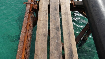 View of old deck,  by the Mediterranean Sea, Israel .Remains of a rusted handrails on a waterfront. Metal corrosion due to frequent exposure to sea water close-up