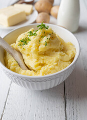 Mashed potatoes in a bowl on white background with space for text