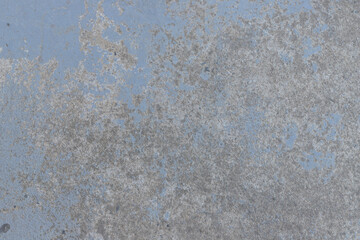 Raw concrete floor painted blue, discolored by the action of time.