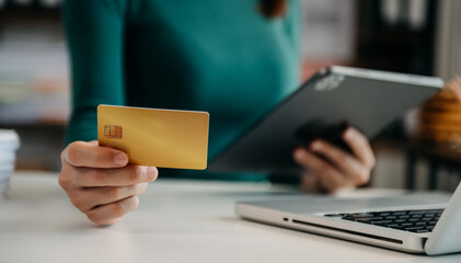Woman using smart phone for mobile payments online shopping,omni channel,sitting on table,virtual icons graphics interface screen in morning light.