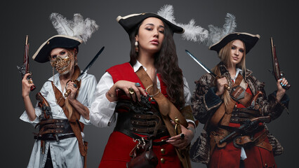 Shot of attractive female buccaneers dressed in antique attire with flintlock guns.