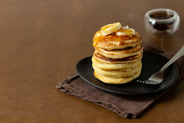 Pancakes stacked with honey and bananas. Brown backstage