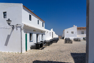 Beautiful square of the village of Aldeia Nova with the white and blue typical houses in a sunny...