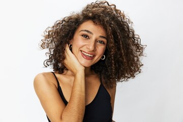 Beautiful woman with curly afro hair posing on a white isolated background smile happiness in jeans and black top emotion, hand signs, copy space