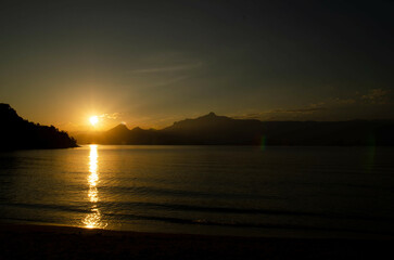Sunset on the beaches of Angra dos Reis, Brazil. With the sun setting over the sea.