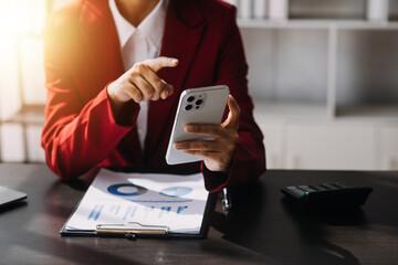 Asian Business woman using calculator and laptop for doing math finance on an office desk, tax, report, accounting, statistics, and analytical research concept