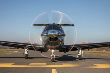 The plane is traveling on the taxiway, its propeller is spinning. Single turboprop aircraft on...
