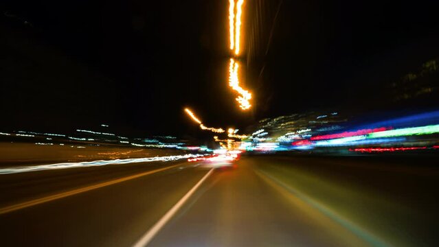 Fast Speed City Drive Timelapse. City Road and Glittering Streets and Buildings All Turning Into Colorful Light Trails. Cityscape Hyperlapse Road Trip. Windshield View