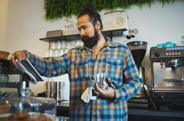 Coffee, tablet and barista reading orders, checklist or inventory online while working at a cafe....