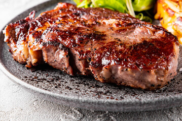 Grilled Ribeye Steak on plate with cheese and salad