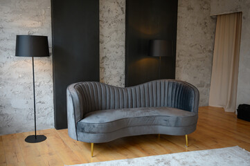 Gray fashionable sofa in a modern interior. with black floor lamp