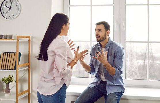 Family couple having a fight. Young man and woman having an argument and quarreling. Husband and wife shouting at each other. Misunderstanding, disagreement and relationship problems concept
