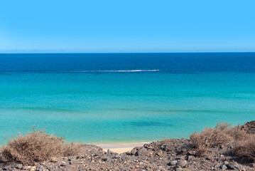Vista panorámica de la playa de arena blanca de Jandia con mar turquesa rodeada de un paisaje...