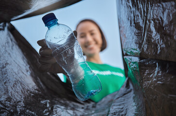Recycling, bottle and woman with view in bag, sustainability and cleaning plastic pollution, earth...
