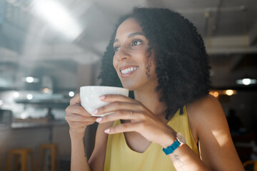 Morning cup of tea, black woman and coffee shop thinking with a young person in a restaurant. Cafe, sitting and happy African female with a hot drink enjoying a day with happiness and an idea