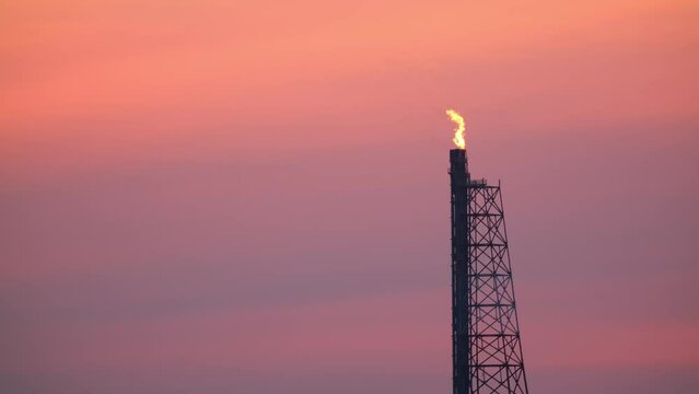 Fire from a pipeline. Oil production. Working oil refinery. Smoke from the factory chimney. Air emissions polluting the city. Gas pipeline at sunset. petroleum-producing