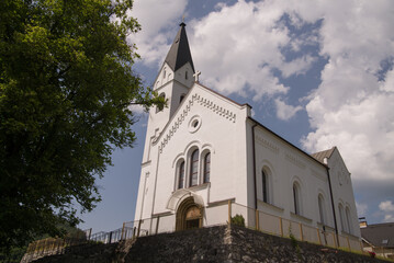 catholic church in summer time with clouds in sky