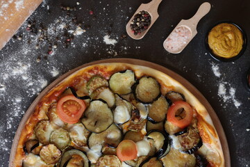 Vegetarian pizza with fried eggplant and zucchini. with the green. Top angle with spices 