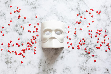 Venetian Bauta mask, Casanova mask on a marble background with confetti hearts. Concept - Venetian...