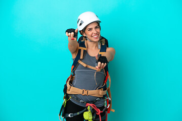 Obraz na płótnie Canvas Young Italian rock-climber woman isolated on blue background points finger at you while smiling