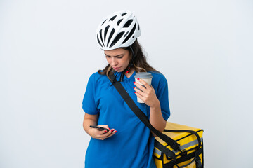 Young delivery woman with thermal backpack isolated on white background holding coffee to take away and a mobile