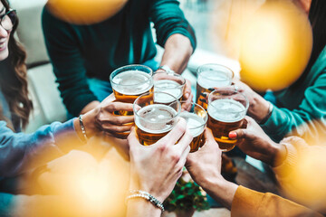 Group of happy friends drinking and toasting beer glasses at brewery pub restaurant - Young people...