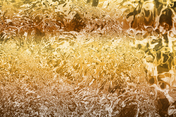 Blurred transparent Yellow Gold colour clear calm water surface texture with splashes and bubbles. Trendy abstract nature background. Water waves in sunlight. water background, oil