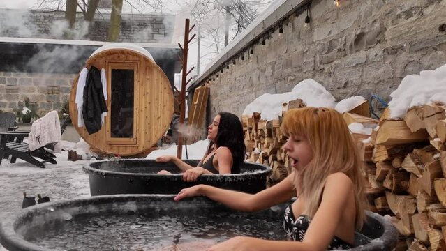 Two women doing an ice bath therapy session