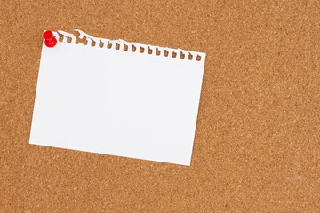 Blank card paper with a pushpin on a corkboard