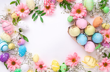 Colorful eggs and flowers on a white background. Easter design in pastel colors with space for text