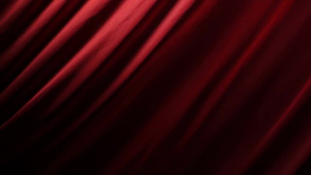 The chic and elegant texture of the moving folds of light red fabric on a black background under dramatic lighting. Slow Motion 200 FPS