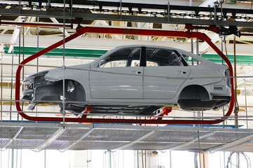 Car body transported by hanging conveyor in plant workshop