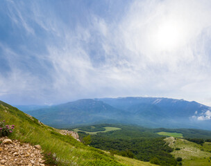 Naklejka premium green mountain under a sparkle sun, green grass and stones outdoor mountain landscape