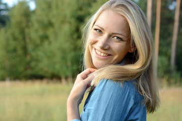 Portrait of a beautiful blonde woman, enjoying the sun on a sunny summer evening in forest and nature