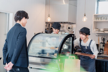 ケーキ屋で楽しく買い物をするビジネスマン