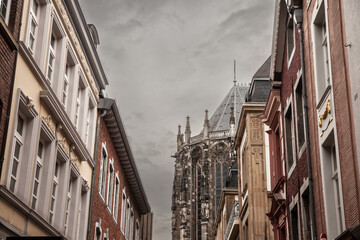 Fototapeta na wymiar Aachen Cathedral seen from the old town with residential buildings. Aachen Cathedral, or Aachener Dom, is the main landmark of Aachen and a catholic church in Germany..
