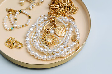 Trendy jewelry with chains, pearl necklace and pendant shapes moon and sun. Stylish golden bijouterie. Fashion accessories.