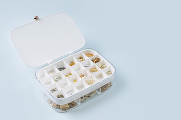 White jewelry box with trendy bijouterie . Chains, necklace, earrings and bracelets in jewelry case. Storage system for women's jewelry. Fashion accessories.