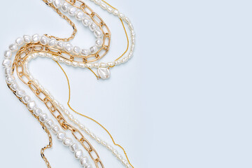 Fototapeta premium Trendy jewelry with chains and pearl necklace. Stylish golden bijouterie. Fashion accessories.