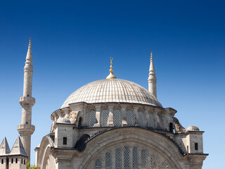 Fototapeta na wymiar Main building of of an ottoman mosque during sunny afternoon; with its dome and minarets in the Fatih district in istanbul, Turkey., on a sunny afternoon. .
