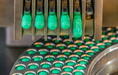 Green capsule medicine pill production line, Industrial pharmaceutical concept.	