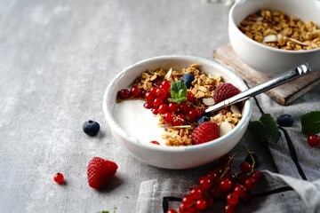 Granola yogurt bowl with rasberries red currants and blueberries | Healthy breakfast concept, selective focus