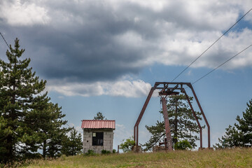 Neglected decaying stopped ski lifts, not working in summer, in Divcibare ski resort, by slopes, in the middle of balkans mountain in Serbia