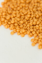 Beautiful golden depilatory wax granules, macro, close up, texture