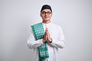 Asian Muslim man wearing white clothes smiling to give greeting during Ramadan and Eid Al Fitr...