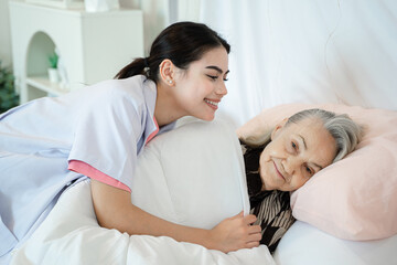 Obraz premium Nurse support supporting senior woman on bed in bedroom at nursing home,Senior services and geriatric care concept.