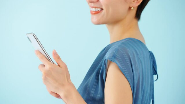 スマートフォンを使うワンピースを着た若い女性	