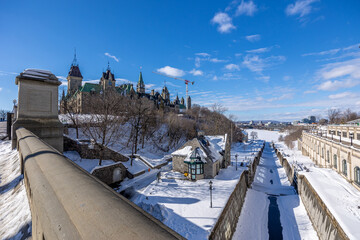 Having a walk on the Parliament Hill in downtown Ottawa Canada with view to the historical buildings of the Canadian parliament and its surroundings at a cold but sunny day in winter. - obrazy, fototapety, plakaty